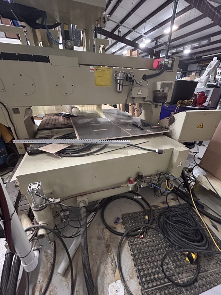 Rear view of the 2000 Anderson Stratos SUP CNC Router showing the gantry, rear machine frame, cable management, pneumatic components, and overall machine condition.